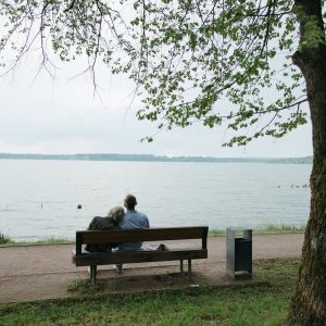 backview of elderly couple sitting on a bench